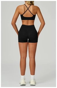 Détail d'un ensemble de yoga noir avec soutien-gorge dos nu et short de sport taille haute