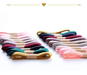 Close-up of colorful 1.5cm double-sided satin ribbons in organized multi-color rolls