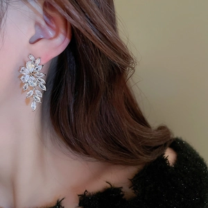Close-up of elegant zircon leaf tassel earrings worn on model for a luxury look