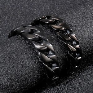 Bracelets gourmette noirs pour hommes en acier poli et mat sur un fond noir élégant