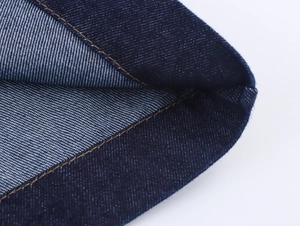 Detailaufnahme der gelben Kontrastnähte auf hochwertigem dunkelblauem Denim-Stoff