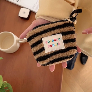 Macro detail of plush striped mini makeup bag showing soft texture and zipper