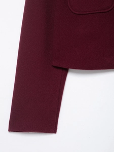 Vue macro détaillée des poignets de la veste en laine bordeaux et des coutures
