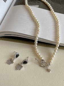 Detail of S925 silver jewelry set featuring black drop earrings and pearl heart necklace