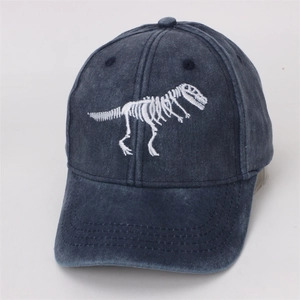 Detail of white dinosaur skeleton embroidery on a dark blue washed cotton baseball cap