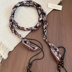 Detail of vintage paisley silk scarf waist belt with woven rope and wooden beads