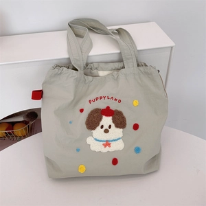 Detailed view of the cute puppy embroidery on a large capacity canvas tote bag for students