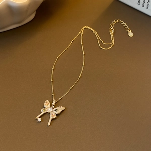 Elegant gold butterfly pendant necklace with zircon paving on brown leather background