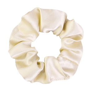 Close-up of beige satin hair scrunchie showing glossy texture and elastic fabric pleats
