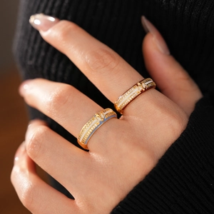 Detailed close-up of 18k gold plated enamel rings with zircons on black knit background