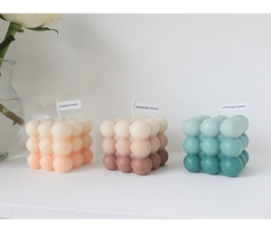Minimalist bubble cube scented candles in pink, brown and teal gradients on white background