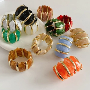 Détail de bracelets en résine acrylique colorée irrégulière avec cadres en métal doré