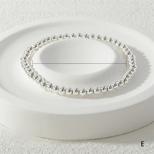 Detailed close-up of a 4mm silver stretch metal bead bracelet on a white display tray