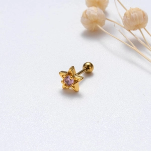 Macro detail of star-shaped stainless steel stud earring with pink zircon and screw back