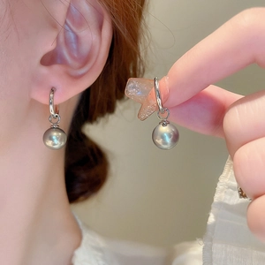 Boucles d'oreilles créoles argentées avec pendentif perle pour un look moderne épuré