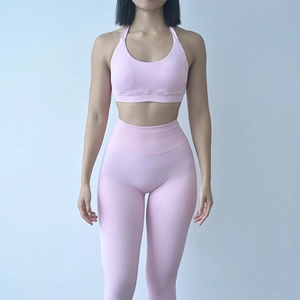 Dettaglio del reggiseno sportivo allacciato al collo rosa e leggings a vita alta sul modello