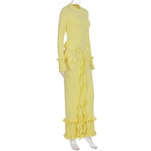 Détail d'une robe moulante jaune montrant le tissu côtelé et les poignets à volants