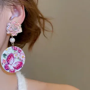Pink floral drop earrings featuring a rose stud, white pearl and butterfly charm
