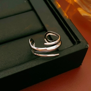 Detailaufnahme eines silbernen mehrlagigen Spiralrings mit minimalistischem hohlem Design