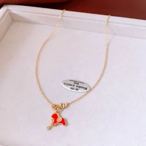 Détail d'un collier plaqué or avec pendentif cheval en émail rouge et cristal brillant