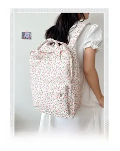 Detail view of floral canvas backpack with dual top handles on a female model