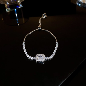 Macro shot of silver adjustable bracelet featuring a square zircon center in a halo design