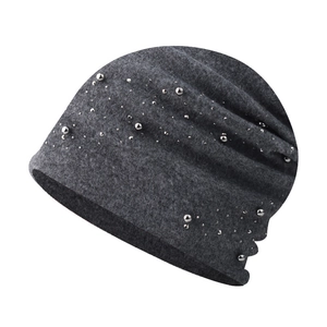 Close-up of grey knit beanie featuring decorative silver beads and soft textured fabric
