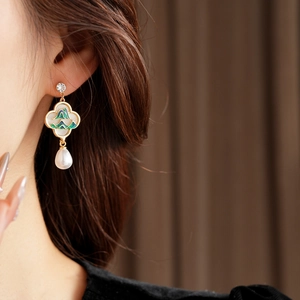 Détail de la boucle d'oreille fleur avec émail vert, perle et zircon élégant