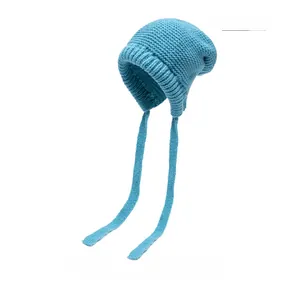 Detailed texture of sky blue chunky knit hat with protective earflaps and tie straps