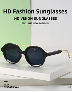 Detail of round black frame sunglasses with gold metal temples on a display stand