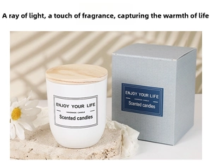 Detail of white glass scented candle with wooden lid and matching gift box on stone base