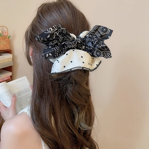 Détail d'un grand nœud à motif paisley et pois attaché sur un chignon élégant