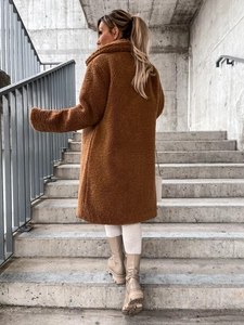 Back view of brown teddy coat featuring long sleeves and cozy fleece texture on stairs