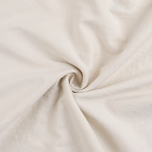 Détail macro du tissu en lin crème doux avec texture naturelle et drapé élégant