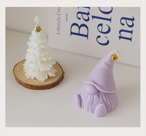 Detail of Christmas tree and gnome scented candles with gold bells on wood base