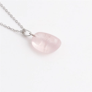Detailed view of irregular pink crystal pendant necklace on a sleek silver chain link