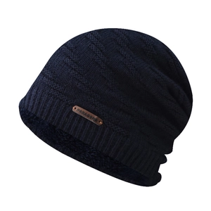 Detail of dark blue knit winter hat featuring warm black fleece lining and leather patch