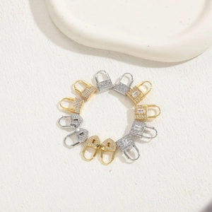 Detailed macro view of heart and square lock charms in gold and silver with zircon