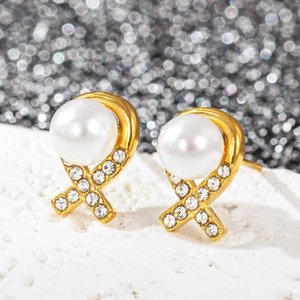Détail de boucles d'oreilles plaquées or 18k avec perles blanches et strass étincelants