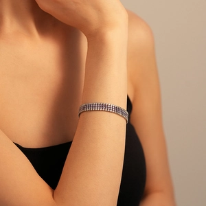 Vue détaillée du bracelet de tennis de luxe à trois rangs serti de zircons violets et blancs