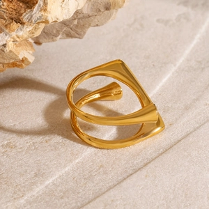 Detailed top view of gold double-layer geometric ring on natural stone background