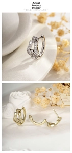 Macro view of gold and silver horseshoe earrings with micro-set zircon and buckle detail