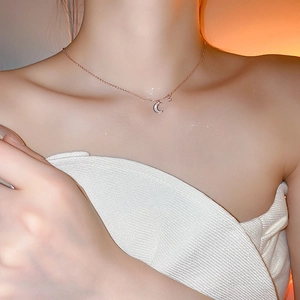 Gros plan du collier choker doré rose avec pendentif lune blanche pour femme