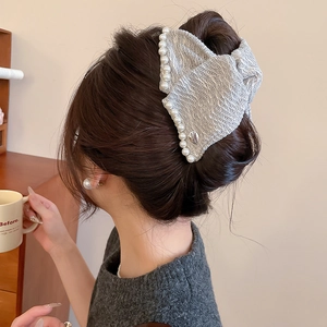 Grey tweed hair claw clip with pearls shown on model in a stylish hair bun