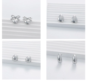 Detailed close-up of four geometric silver steel earrings in various minimalist shapes