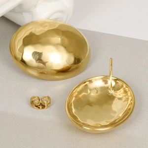 Macro detail of gold 304 stainless steel teardrop earrings with hammered texture and backings