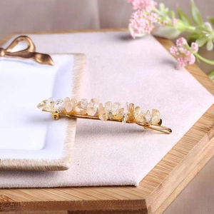Detail of yellow natural crystal stones on a golden metal hair clip accessory
