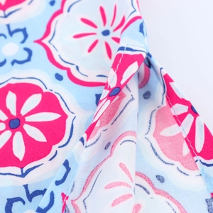 Close-up of geometric floral print on light blue fabric with precise stitching details