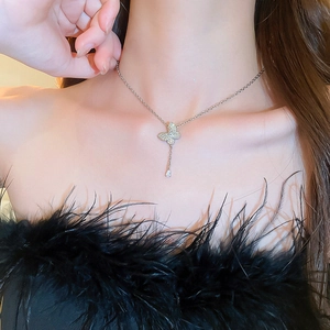 Close-up of silver butterfly necklace with pave zircon and drop-shaped crystal pendant