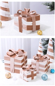 Close-up of pink and white striped velvet Christmas gift box set with plush bows